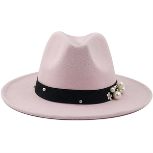 Detail eines hellrosa Fedora-Huts mit schwarzem Rippband, Perlen und floralem Akzent