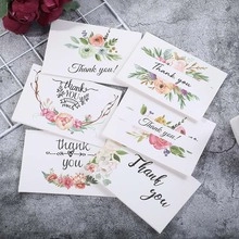 Flat lay of watercolor floral thank you greeting cards on grey marble background
