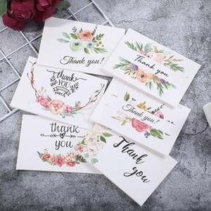 Variety of watercolor floral Thank You cards on a grey stone surface with dried flowers