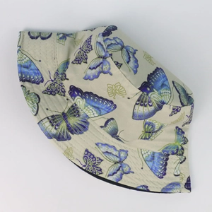 Détail du chapeau de soleil en coton avec imprimé papillon et coutures précises sur le bord