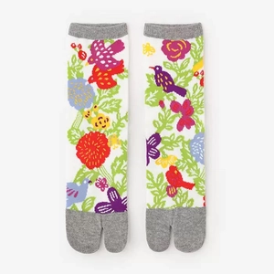 Detailed view of white Tabi split-toe socks with colorful floral and bird jacquard patterns