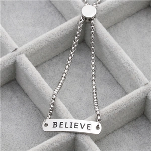 Detailed close-up of adjustable stainless steel bracelet featuring BELIEVE engraving