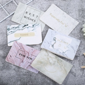Variety of marble texture greeting cards with gold foil lettering on a grey background