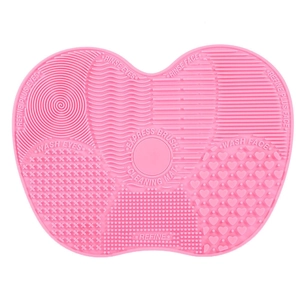 Pink silicone makeup brush cleaning mat with suction cups and various textures