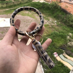 Close-up of leopard print PU leather bangle keychain with tassel and gold spring clasp