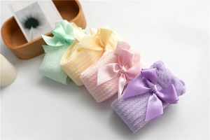Close-up of mesh knit baby socks with silk bows in assorted pastel macaron colors