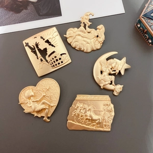 Detailed flat lay of matte gold vintage Baroque brooches with cupid and landmark reliefs