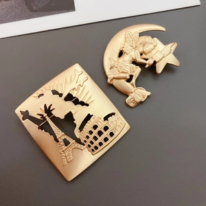 Detail of matte gold brooches featuring Eiffel Tower, Colosseum and Cupid on a crescent moon