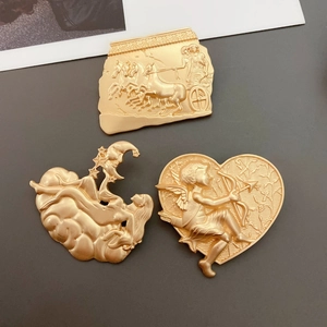 Detail of three matte gold baroque pins featuring ancient Egyptian and Cupid relief carvings