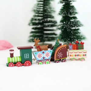 Classic red and green wooden Christmas train with reindeer and tree ornaments on white snow
