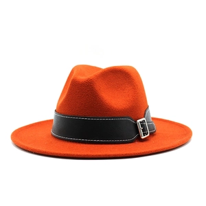 Detail of orange wool fedora hat featuring a black leather band and silver square buckle
