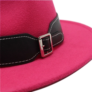 Detailed macro view of magenta wool fedora with black leather band and silver buckle