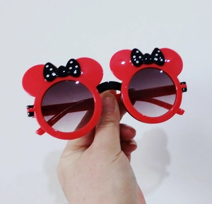 Close-up of red cartoon sunglasses with black polka dot bow and round ears