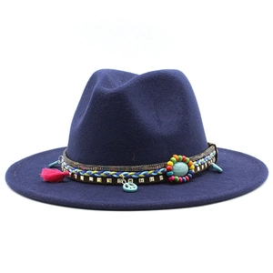 Detail of navy blue felt fedora featuring bohemian band with tassels and peace charm