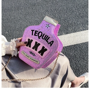 Detail of glitter purple tequila bottle shaped crossbody bag with gold chain strap