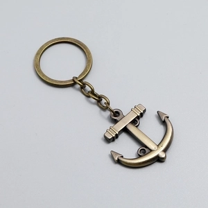 Vintage bronze sailing anchor keychain with antique metal finish on grey background