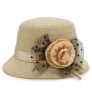 Elegant beige woven cloche hat with a large satin rose and black polka dot mesh detail