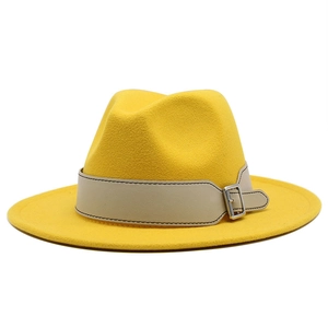 Classic yellow wool fedora hat with beige leather band and silver buckle on white background