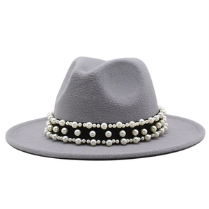 Détail d'un chapeau fedora gris en laine avec élégantes perles nacrées sur le ruban