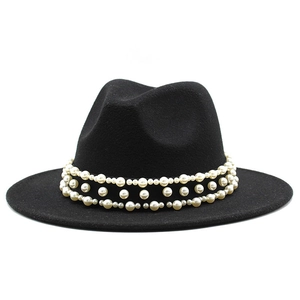 Détail d'un chapeau fedora noir en laine orné de trois rangées de perles blanches nacrées