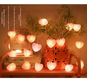 Detail showing heart-shaped LED string lights with warm pink glow and frosted texture