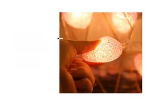 Detail of pink heart-shaped LED lights showing flexible soft texture and warm orange glow