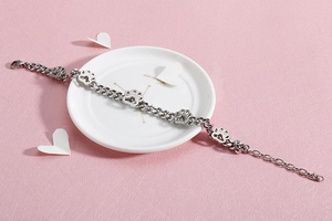 Detailansicht eines silbernen Edelstahl-Armbands mit Pfotenabdruck auf einem weißen Teller