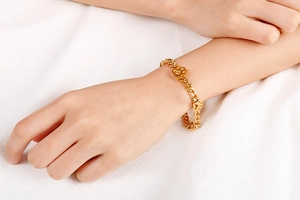 Detailaufnahme eines goldfarbenen Pfotenabdruck-Anhängers an einem minimalistischen Armband