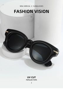 Close-up of black thick frame sunglasses with metal details and UV protection lenses