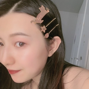 Three-piece rose gold hair clips with cat and star designs worn by a model