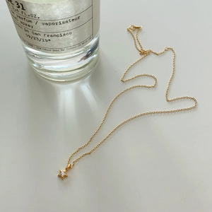 Detail of gold star pendant necklace with crystal inlay against aesthetic background