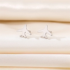 Polished stainless steel airplane stud earrings displayed on elegant beige silk fabric