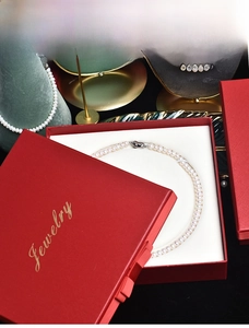 Close-up of white natural freshwater pearl necklace in a premium red jewelry gift box