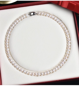 Detailed view of a white freshwater pearl necklace inside a premium red gift jewelry box