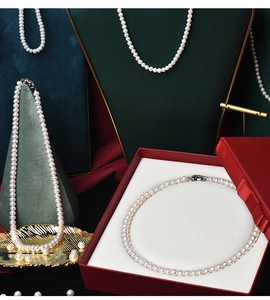 Detailed close-up of natural round pearl necklaces in a luxury red gift jewelry box