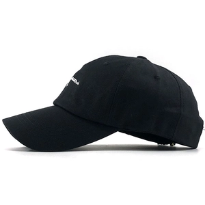 Detail of black cotton baseball cap with white AK-47 rifle embroidery on the side