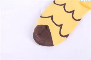 Macro detail of cute cartoon cat socks featuring yellow wave patterns and brown toe stitching