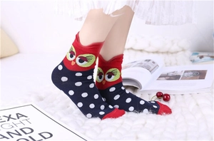 Detailed close-up of cute owl cartoon socks with red polka dots and soft cotton texture