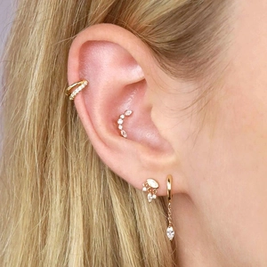 Close-up of gold marquise zircon drop earrings and ear cuffs on a female model