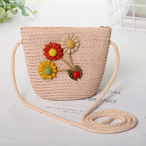 Detailed view of child straw bag with colorful floral and ladybug accents
