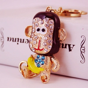 Porte-clés singe mignon avec cristaux et banane jaune sur support en métal doré