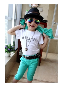 Close-up of boys white printed T-shirt and mint green pants with stylish accessories