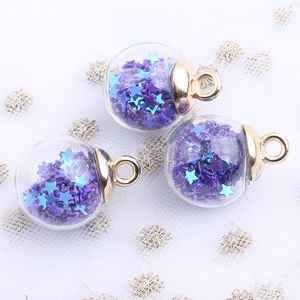 Detail of transparent glass spheres filled with purple and blue star sequins for DIY crafts