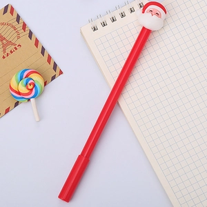 Red Christmas Santa Claus pen on a white grid notebook with festive holiday props