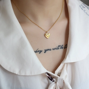 Elegant 18K gold-plated heart pendant necklace with beaded edges on a delicate ball chain