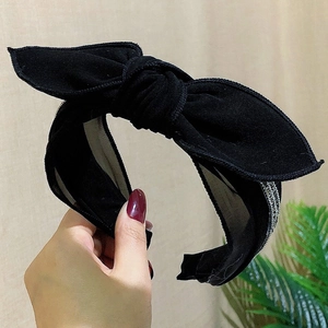Detail of black polka dot mesh headband with knotted bow and non-slip inner design