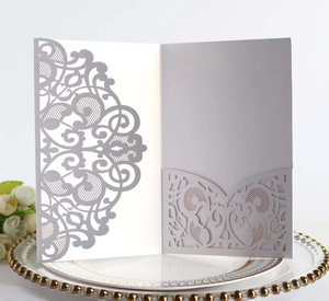 Macro detail of silver laser-cut lace wedding invitation with intricate baroque hollow patterns
