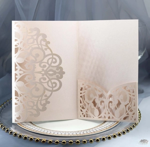 Detail of laser-cut champagne pearlescent paper wedding invitation with floral pattern