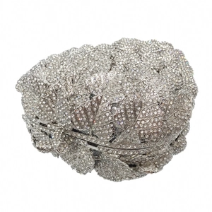 Detailed view of silver leaf-shaped clutch bag with luxury crystal and rhinestone setting