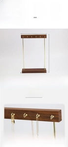 Detail of a 12-hook gold metal necklace display stand with a solid walnut wood base